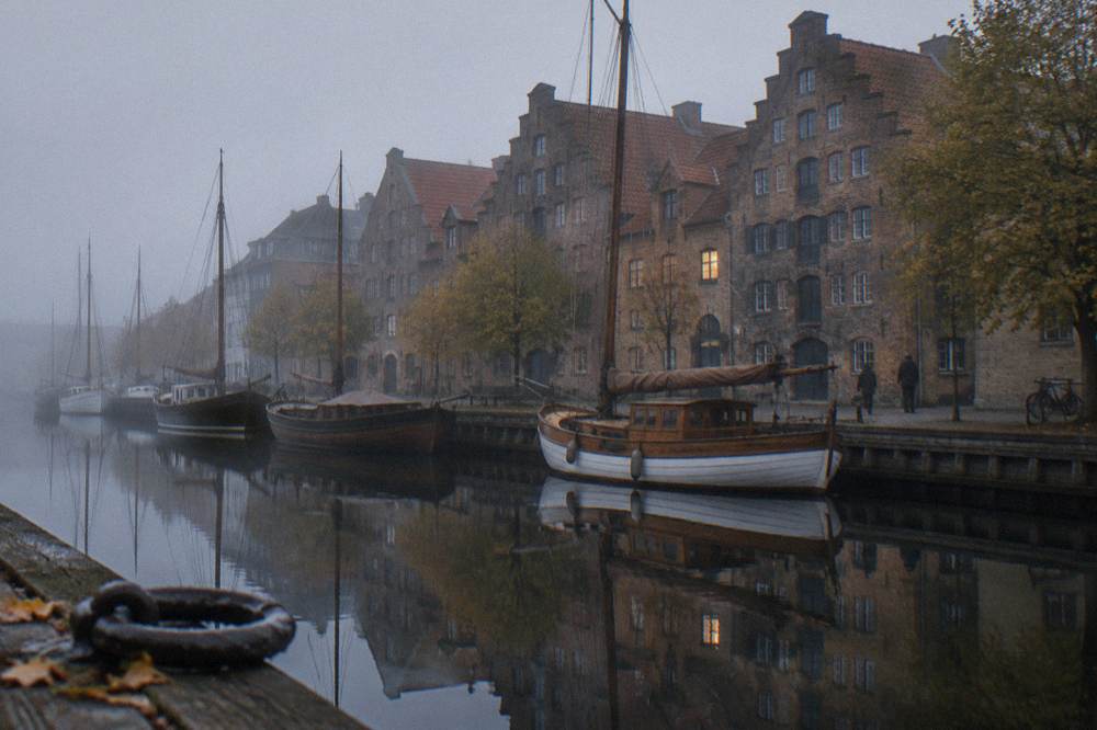 A quiet canal in Christianshavn with wooden boats and old warehouse buildings