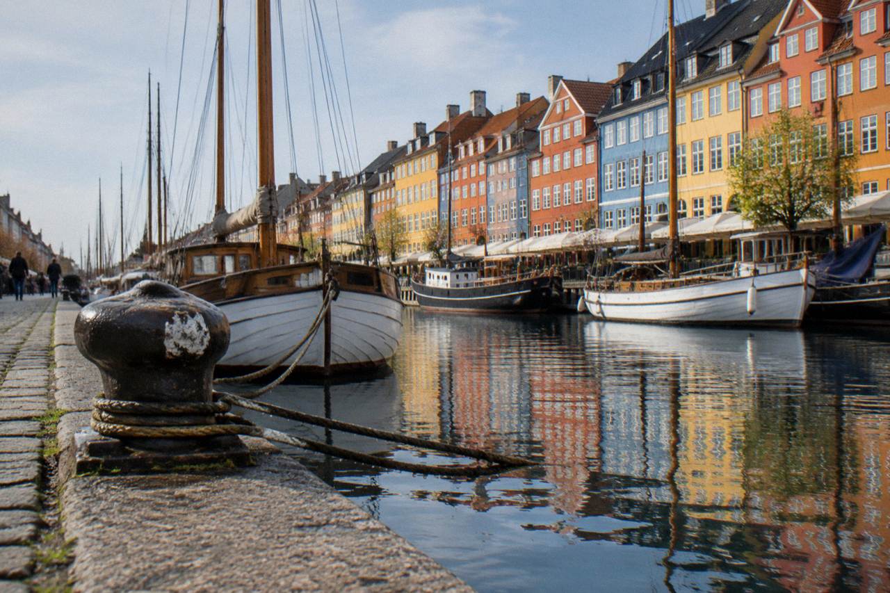 Colourful historic townhouses along the Nyhavn canal in Copenhagen on a bright day