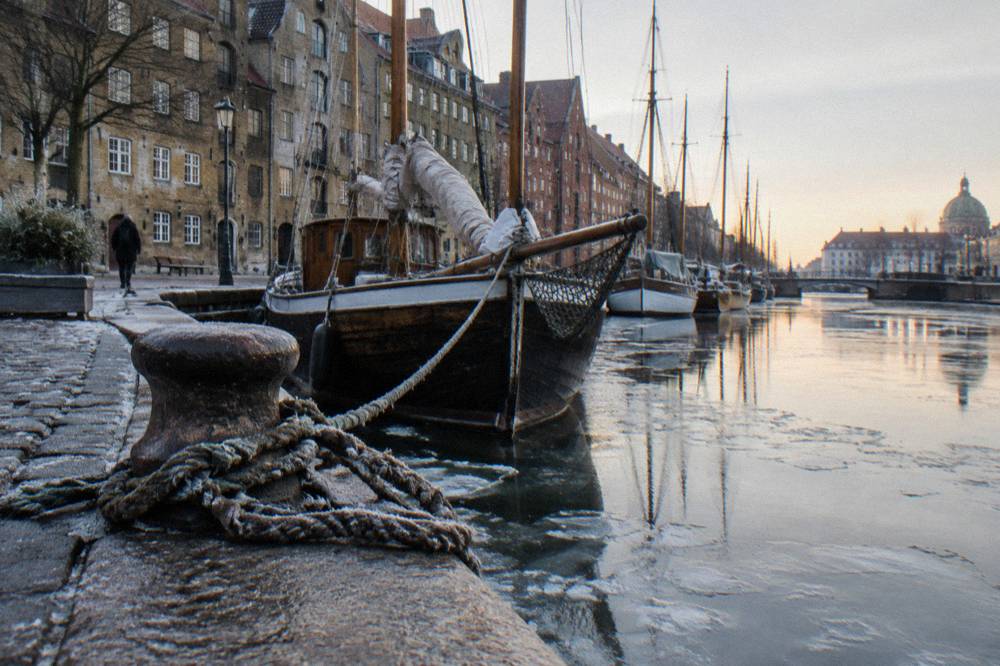Almacenes junto al canal y barcos de madera amarrados en el barrio de Christianshavn