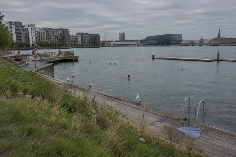 Bañistas en una plataforma de madera de los baños portuarios en el puerto interior de Copenhague