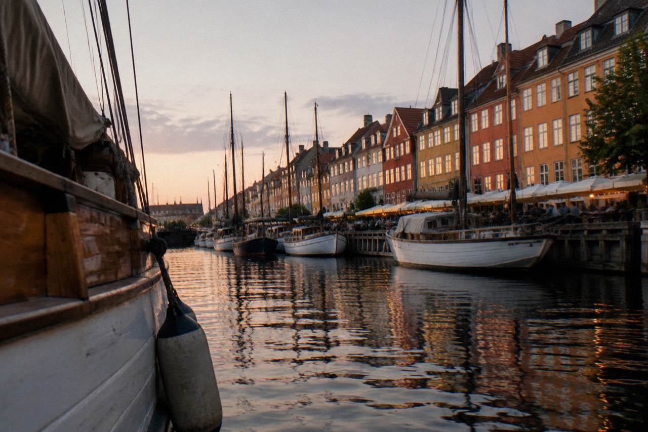 Colourful gabled townhouses along the Nyhavn canal in Copenhagen with moored boats