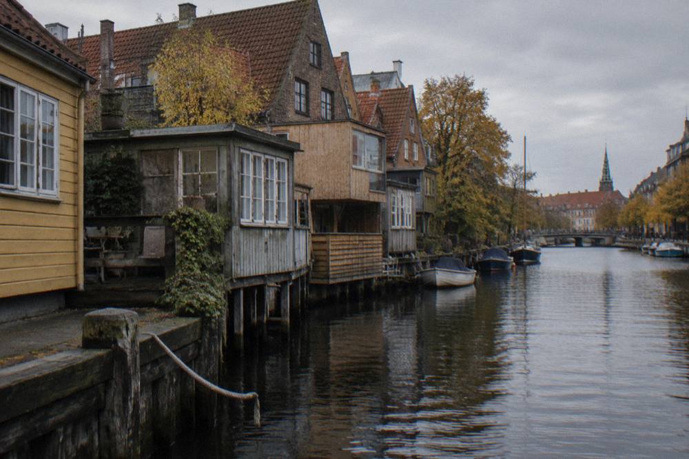 Painted timber houses with improvised extensions beside a canal