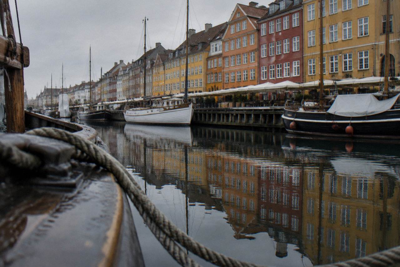 Colourful gabled townhouses reflected in the calm water of the Nyhavn canal