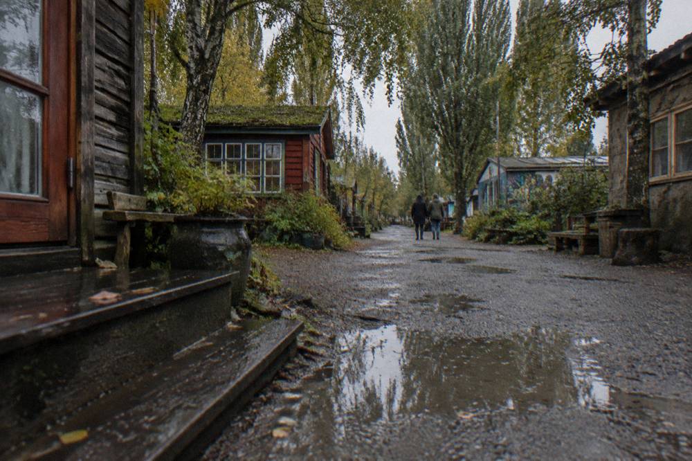 Un camino de grava tranquilo en Christiania con pequeñas casas de madera y árboles