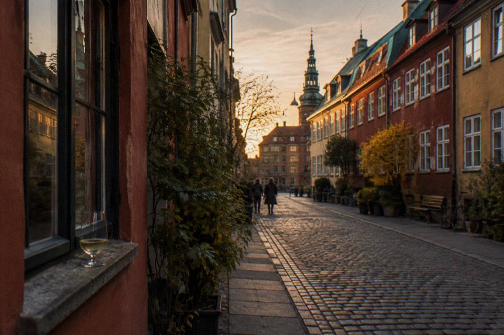 Old Copenhagen townhouses in warm light along a quiet city street