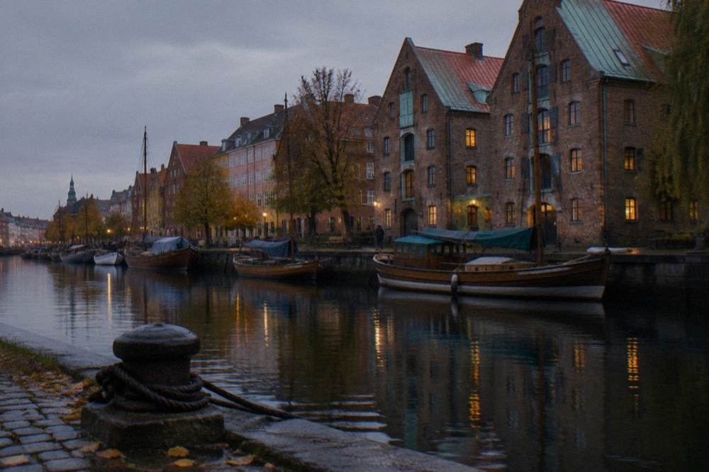 Canal-side Copenhagen houses and moored boats along the water in daylight