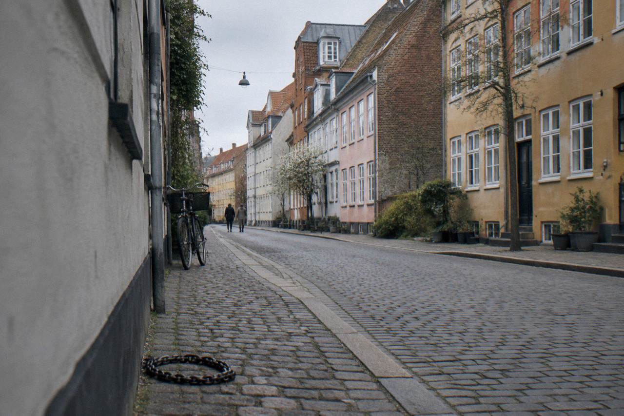 Quiet Copenhagen street with old colourful townhouses under a soft morning sky