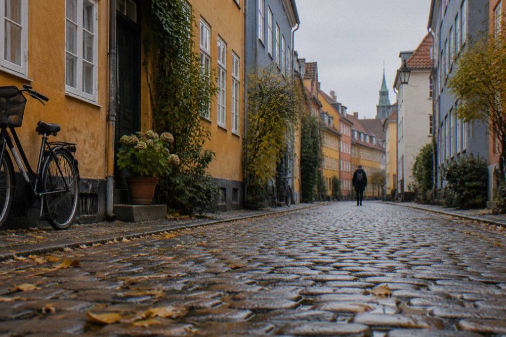 Una calle empedrada en el centro de Copenhague con casas antiguas de colores