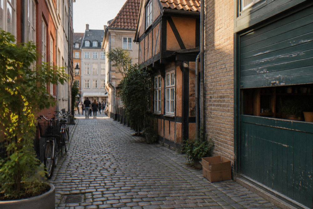 Una calle histórica de Copenhague con fachadas de casas de colores pastel y adoquines