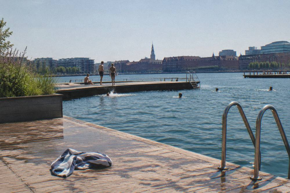 People swimming at a wooden harbour bath platform in Copenhagen