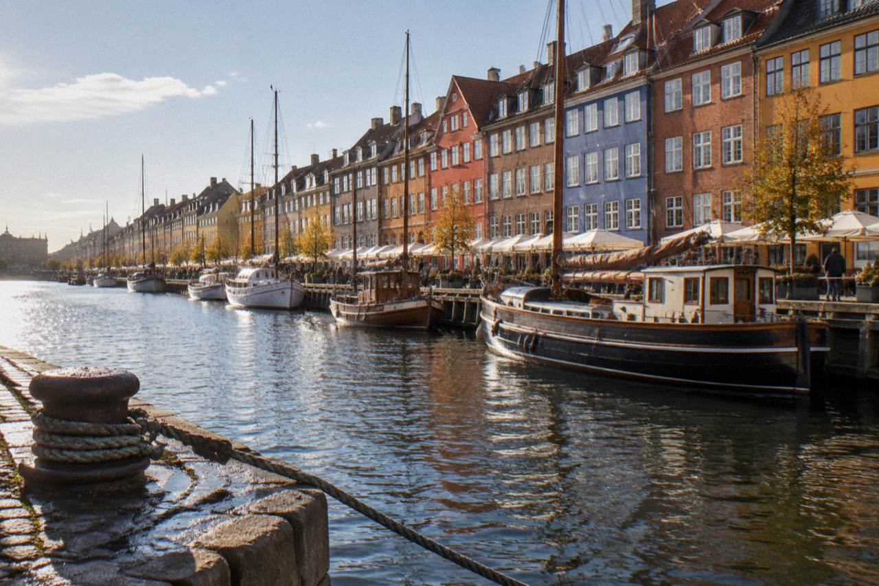 Colourful gabled townhouses along a canal in Copenhagen with moored boats