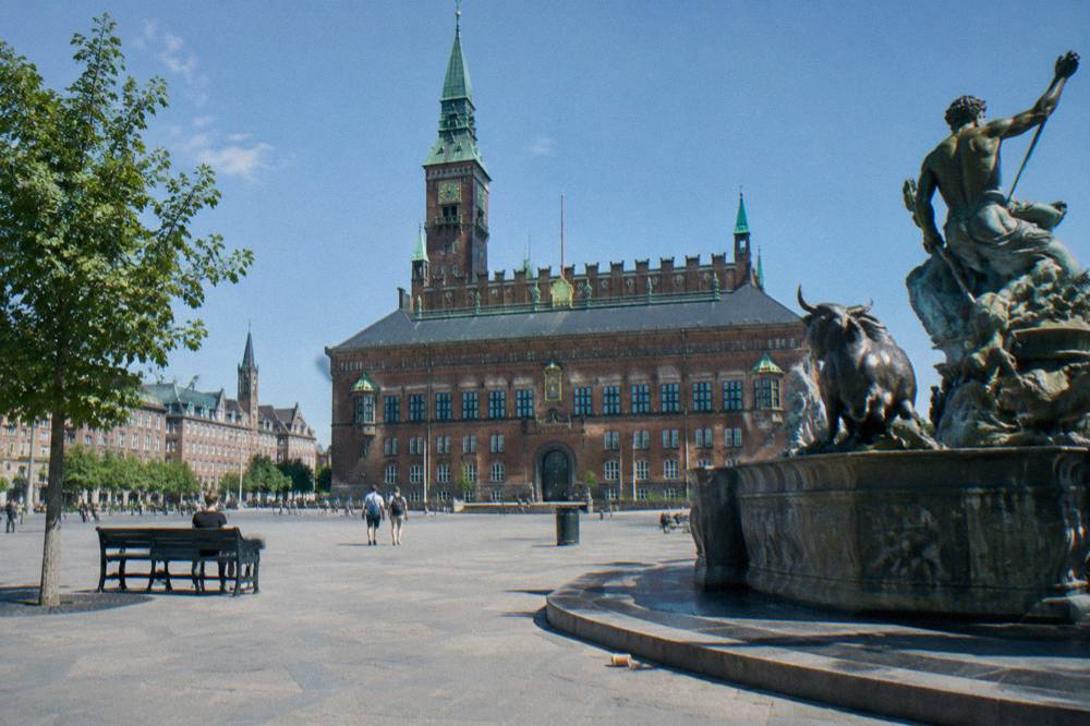 Copenhagen City Hall square with the red brick facade and statues under a clear sky