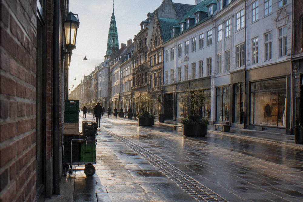 Pedestrian shopping street in central Copenhagen with storefronts and bicycles