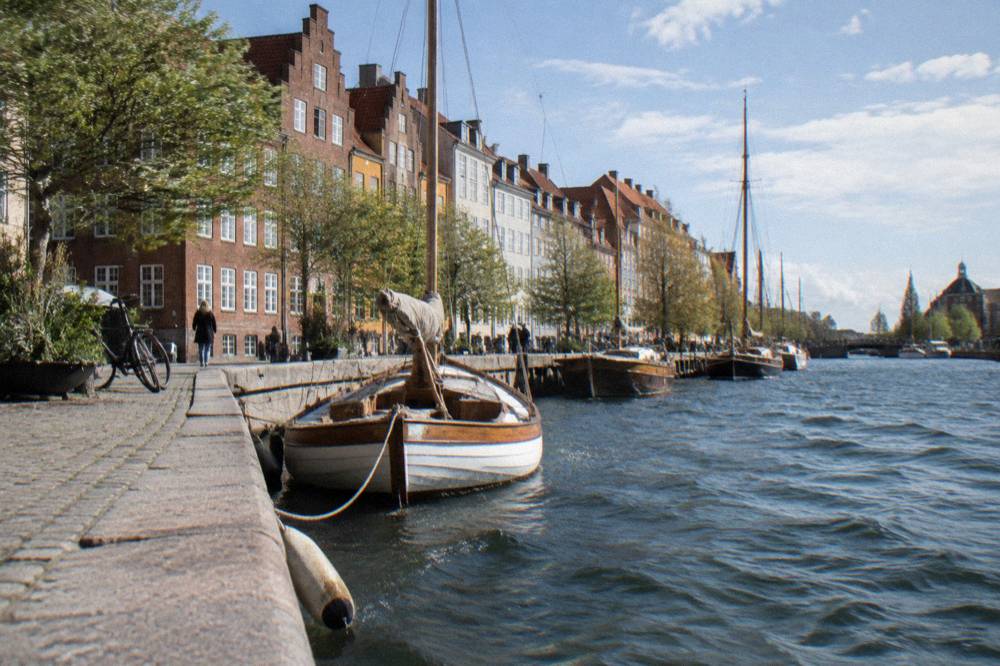 Calle junto al canal en Christianshavn con barcos amarrados y casas de colores a orillas del agua