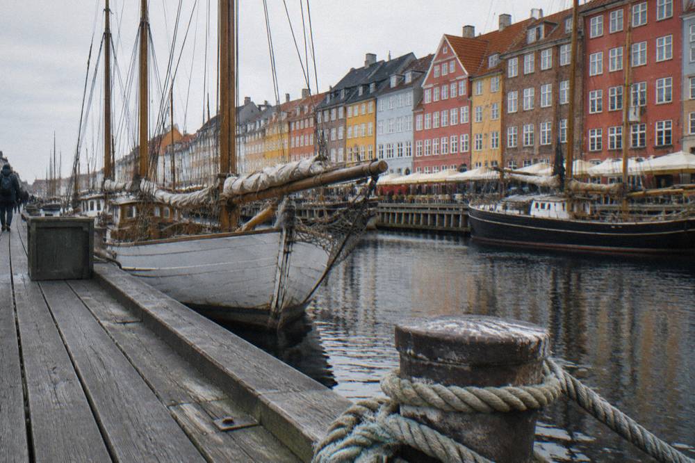 The Nyhavn canal in Copenhagen lined with coloured gabled houses and old wooden ships
