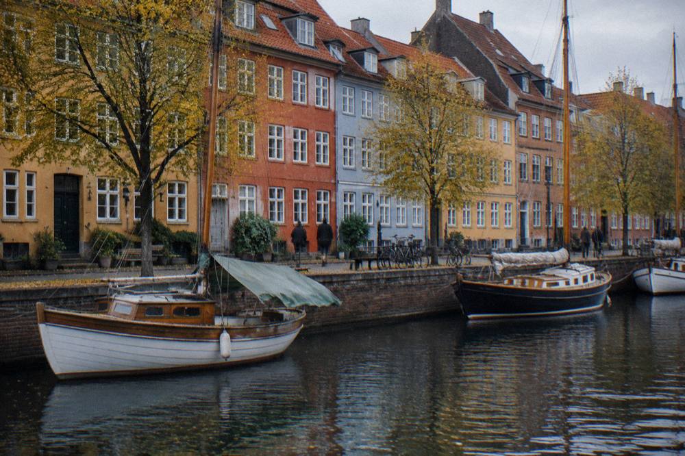 Canal-side street with coloured townhouses and moored boats