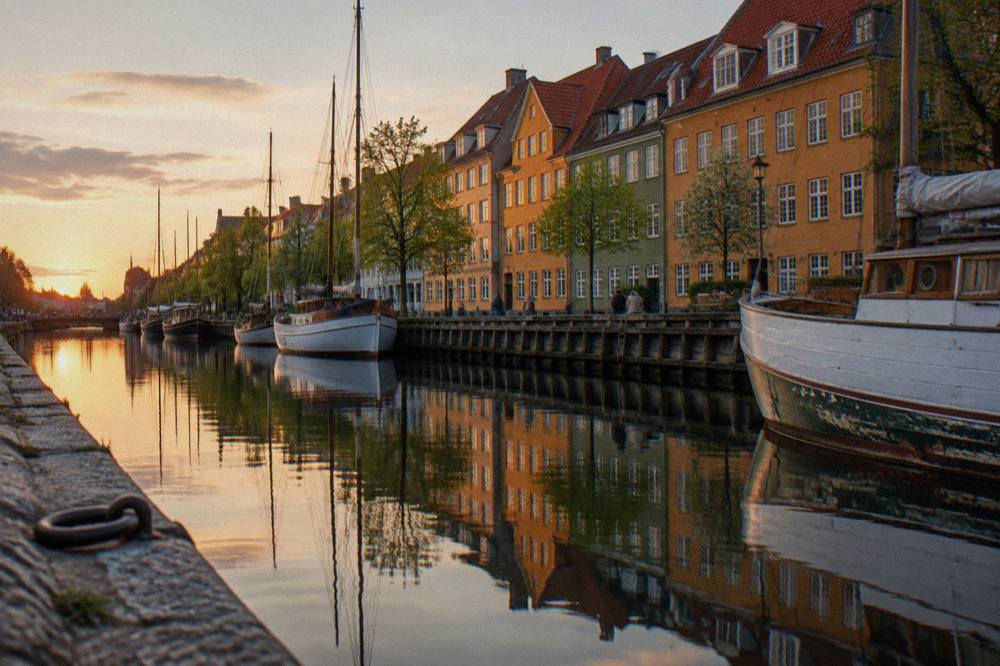 A canal in Christianshavn with old gabled houses reflected in still water