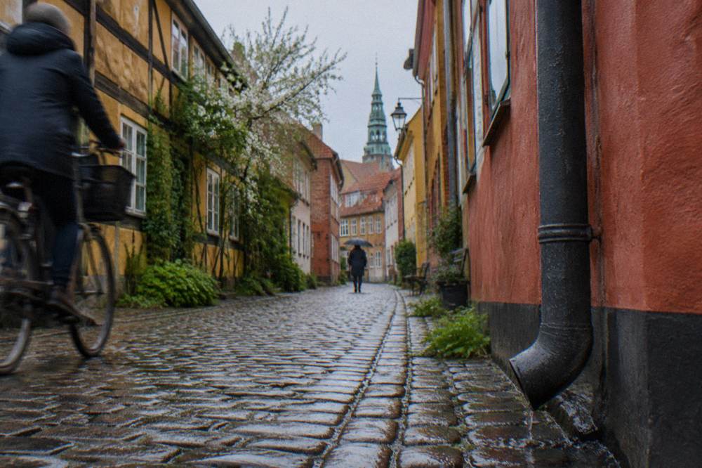 A narrow Copenhagen old town street with colourful facades above a cobbled lane