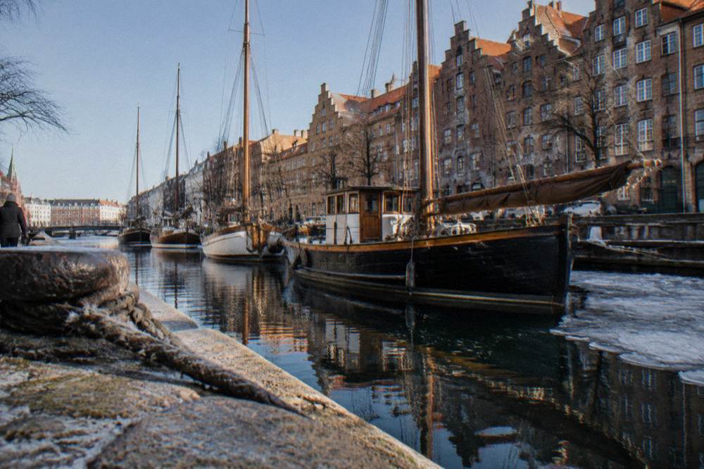 Canal in Christianshavn with wooden boats and old warehouse facades