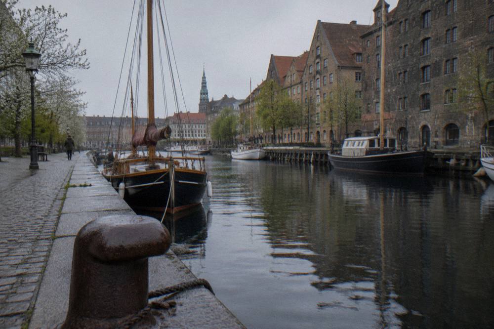 Old warehouse facades and moored boats along a quiet canal in Christianshavn