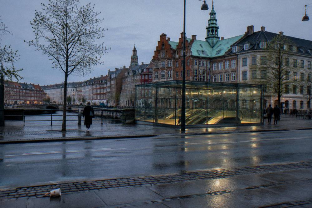 A metro station entrance on a Copenhagen street with bicycles parked alongside