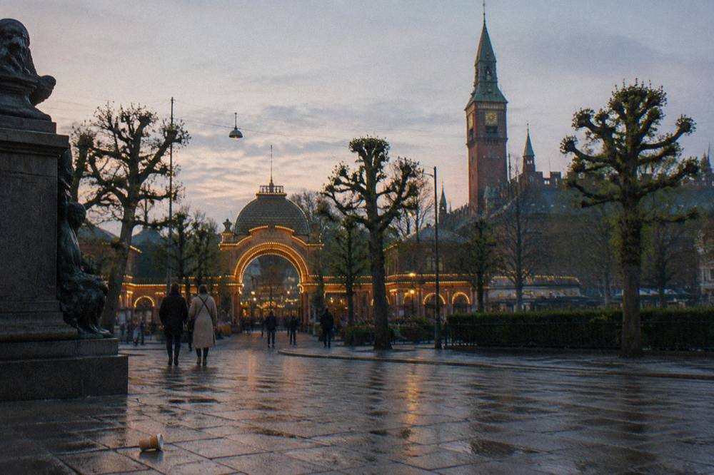 The entrance gate and gardens of Tivoli Gardens amusement park in Copenhagen seen from the street outside