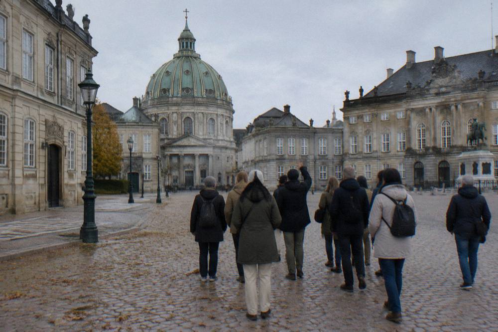 Group of walkers gathered around a guide in a European city square