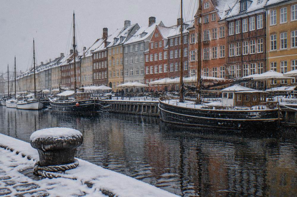 Colourful historic townhouses along a canal lined with old ships