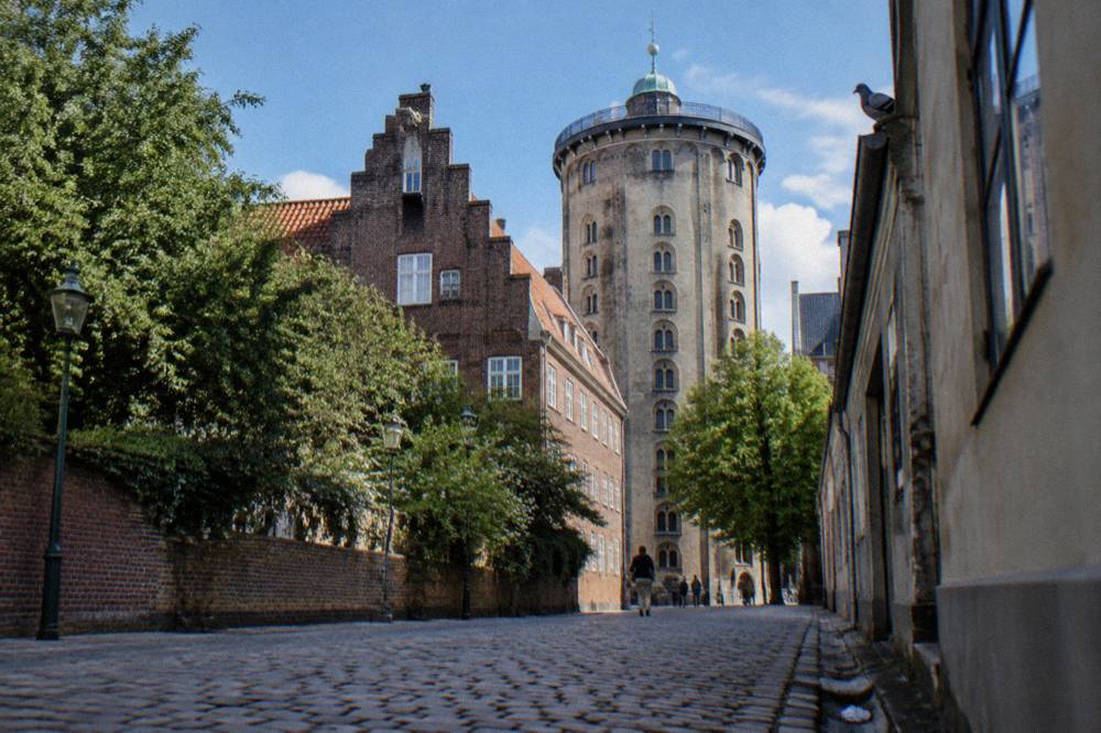 A stone tower observatory rising above old city rooftops
