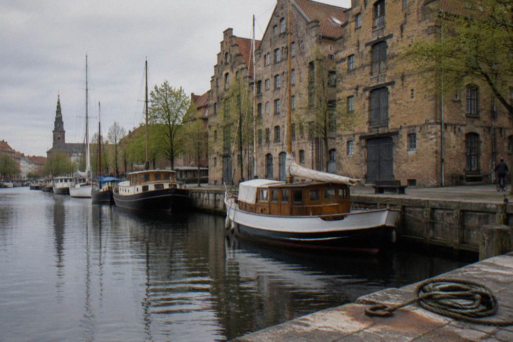 Canal boats moored beside a historic warehouse district with brick facades